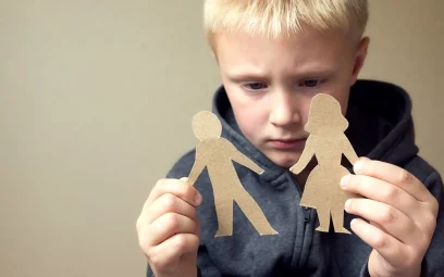 upset boy with paper people cut outs
