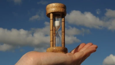 egg timer in person's hand representative of time running out