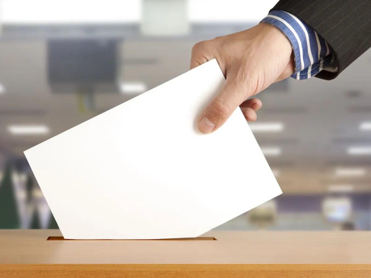 Posting a piece of paper into a voting ballot box