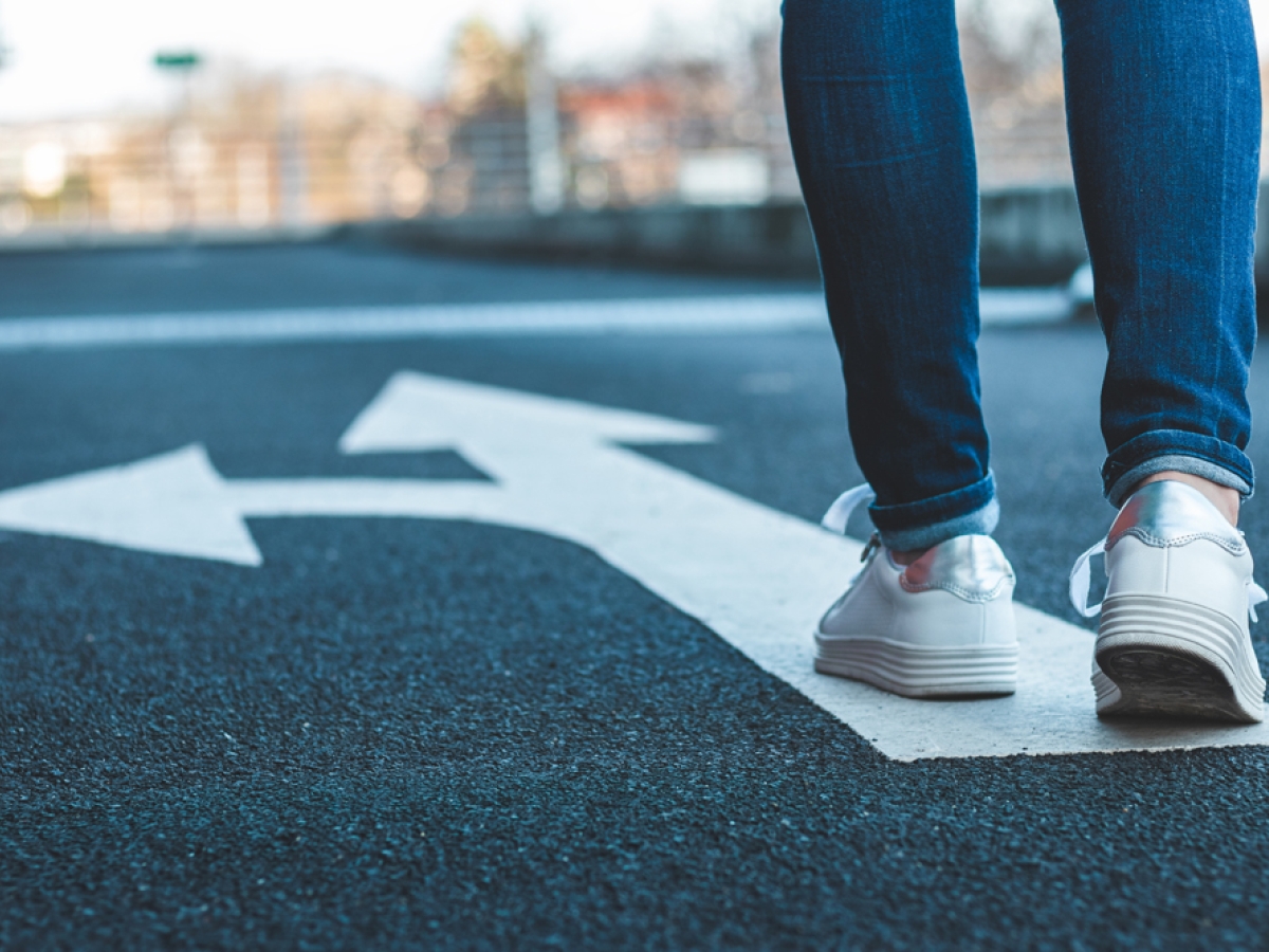 female walking on road with arrows female walking on road with arrows
