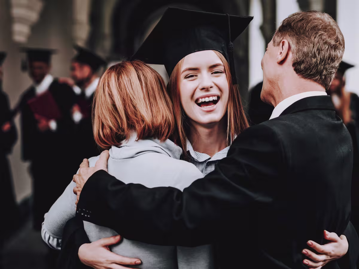 female student hugging parents at graduation