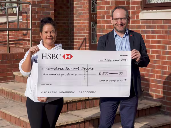 Becky from Homeless Street Angels receives a donation from Winston Solicitors in Roundhay, Leeds