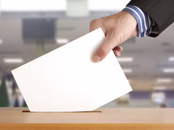 Posting a piece of paper into a voting ballot box