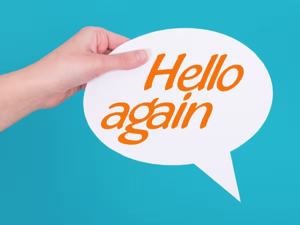 hand holding speech bubble saying hello again