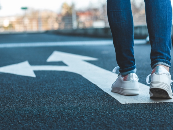 female walking on road with arrows