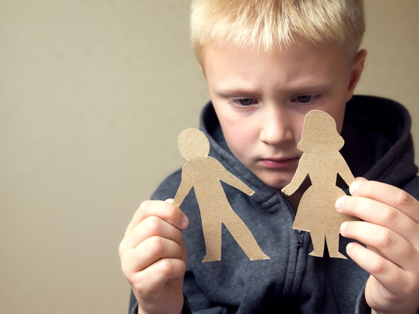 upset boy with paper people cut outs